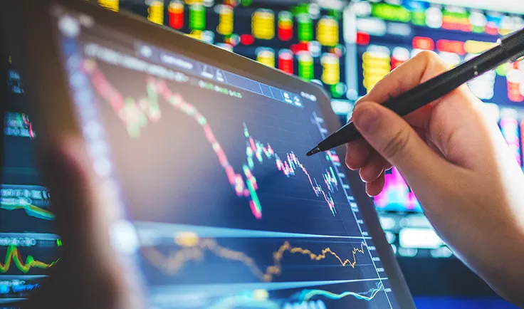 Hand using a stylus on a tablet displaying stock market charts. Hand using a stylus on a tablet displaying stock market charts.