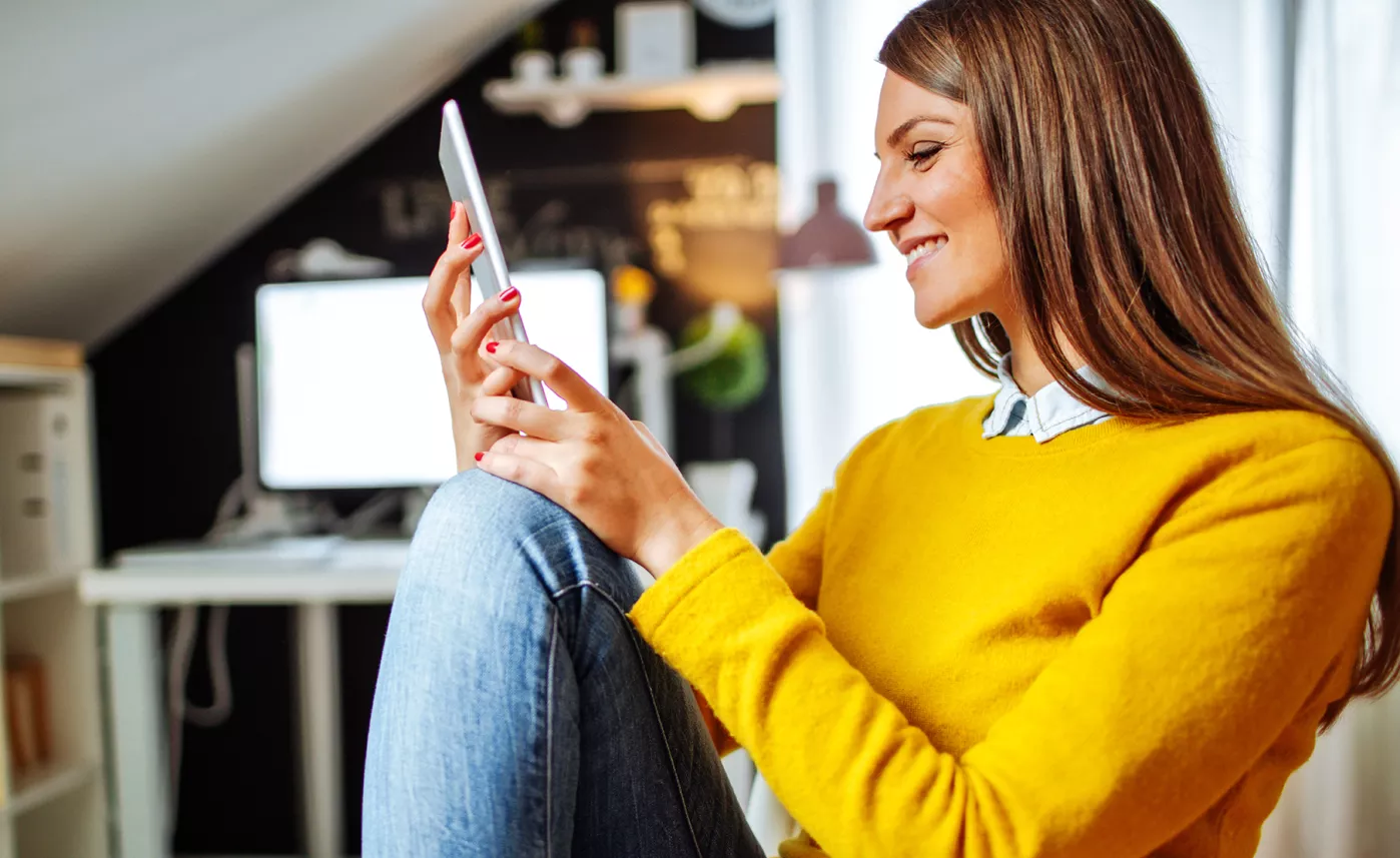  A young woman checks her tax forms from her mobile phone.
